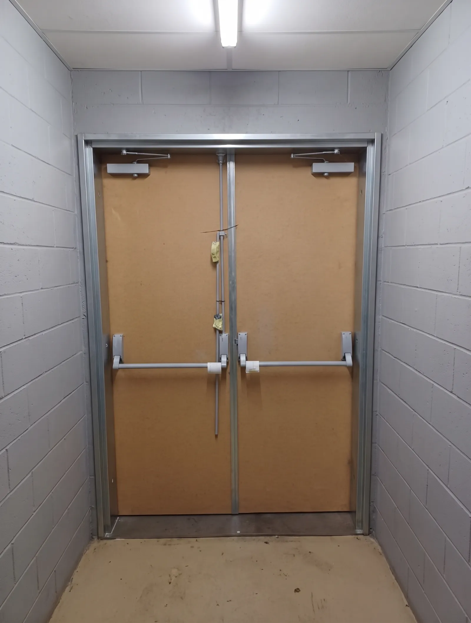 Double escape doors with twin push bars in a corridor